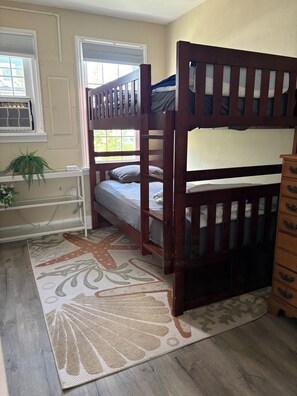 A bunk bed room with a desk, a dresser, and a patterned rug. - 5 Bedroom Beach House Steps to Beach and Boardwalk (Ocean City)