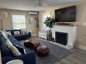 A living room with a sectional sofa, a fireplace, a television, and a ceiling fan. - 5 Bedroom Beach House Steps to Beach and Boardwalk (Ocean City)