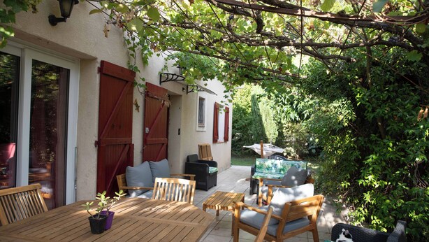 An outdoor patio with wooden furniture, a table, and chairs. - Piano in the Shadow of the Festival (La Roque-d'Anthéron)