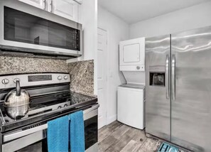 A kitchen with a stainless steel refrigerator, a microwave, and an oven.