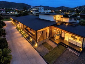 Een modern hotel met een overdekt terras, een receptiebalie en uitzicht op het omliggende landschap.