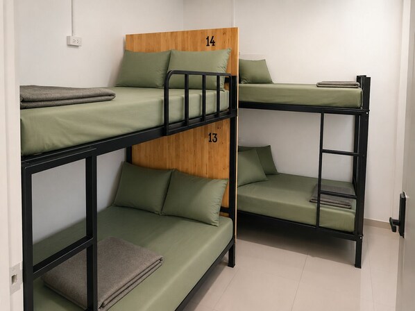 A bunk bed room with three levels, each with a wooden headboard and green bedding. - Smith & Appy Backpackers Hostel (Koh Samui)
