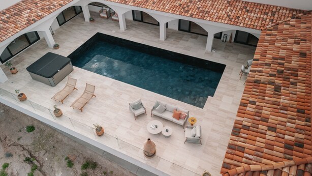 An aerial view of a rooftop swimming pool with a tiled roof, lounge chairs, and a seating area. - Self Contained Sanctuary & Speedboat (La Paz)