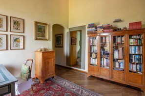A room with a wooden cabinet, a desk, a chair, a rug, and a bookshelf. - Country Charm in Florence (Montebeni)