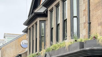 A corner building with a stone facade, multiple windows, and a sign for 'Uno'.