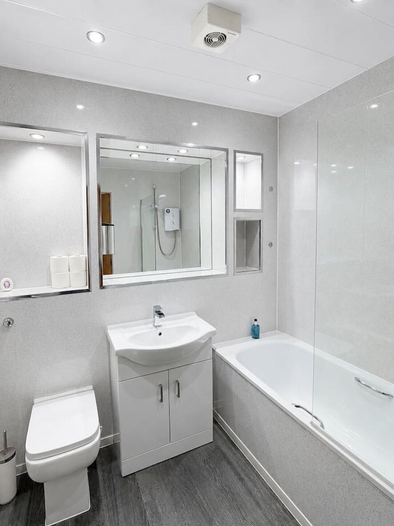 Et moderne badeværelse med toilet, vask og badekar.