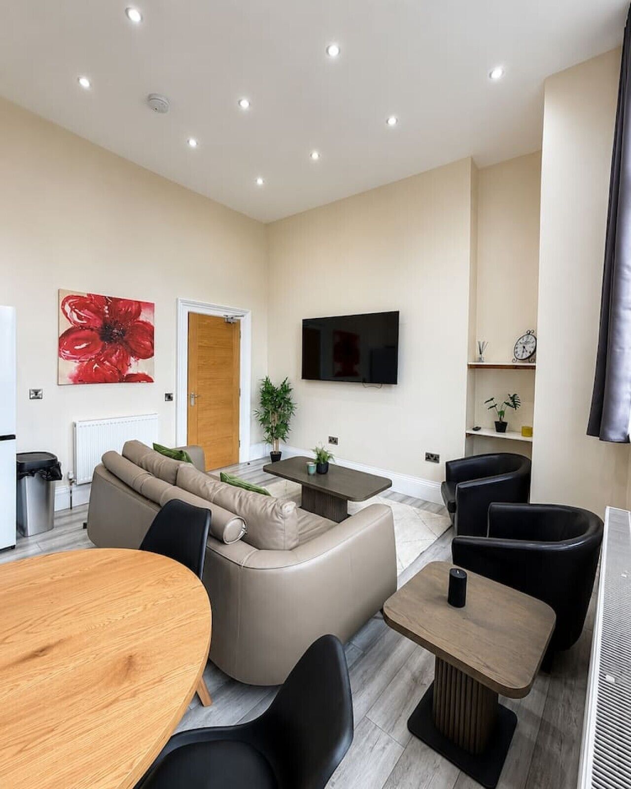 Ein modernes Wohnzimmer mit einer Couch, einem Couchtisch und einem an der Wand befestigten Fernseher.