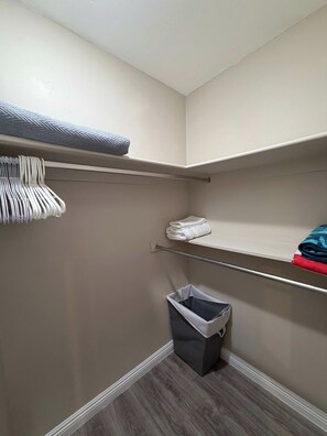 A closet with shelves, a hanging rack, and a trash bin. - NEW Desert Gem | Spacious 2BR Tucson Getaway (Tucson)