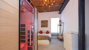Une chambre à coucher avec un lit, une armoire, un miroir et un lustre.