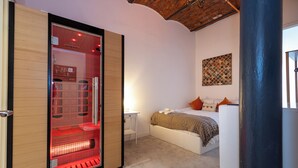 Une chambre à coucher comprenant un lit, une table de chevet, un radiateur et une œuvre d’art accrochée au mur.