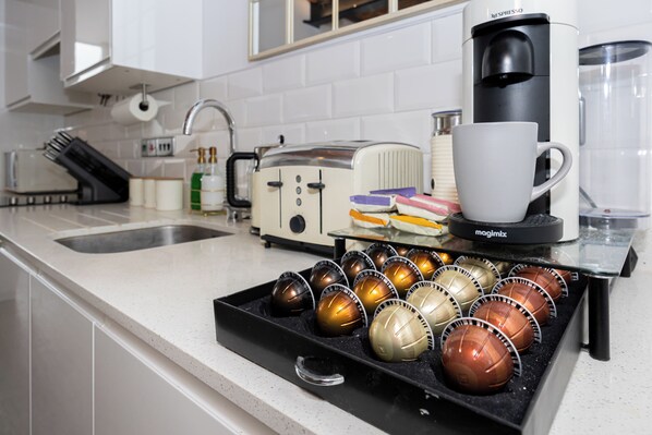 A kitchen with a coffee maker, a toaster, and a tray of eggs.
