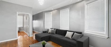 Una sala moderna con un sofá modular, una mesa de centro y una lámpara de techo.