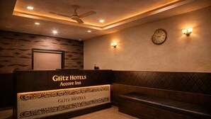 A hotel reception area with a reception desk, a clock, and a seating area. - Accore Inn By Glitz Hotels (Mumbai)