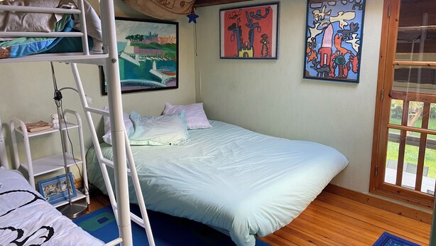 A room with a bunk bed, a ladder, a bed with white bedding, a blue rug, and two framed artworks on the wall. - Large house with a pool and spacious grounds in La Rochelle. (La Rochelle)