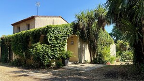 A building with a tiled roof, surrounded by greenery and a gravel path. - Large house with a pool and spacious grounds in La Rochelle. (La Rochelle)