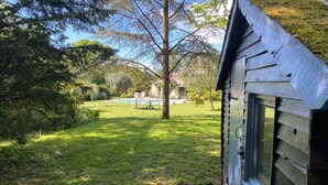 A wooden cabin with a window, surrounded by a grassy yard and a pool. - Large house with a pool and spacious grounds in La Rochelle. (La Rochelle)