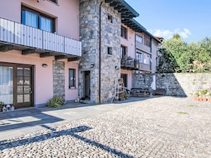 A building with a stone facade, a balcony, and a cobblestone courtyard. - Natalina by Interhome (Cocquio Trevisago)
