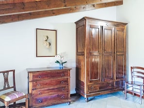 A room with a wooden cabinet, a chair, and a framed picture on the wall. - Natalina by Interhome (Cocquio Trevisago)