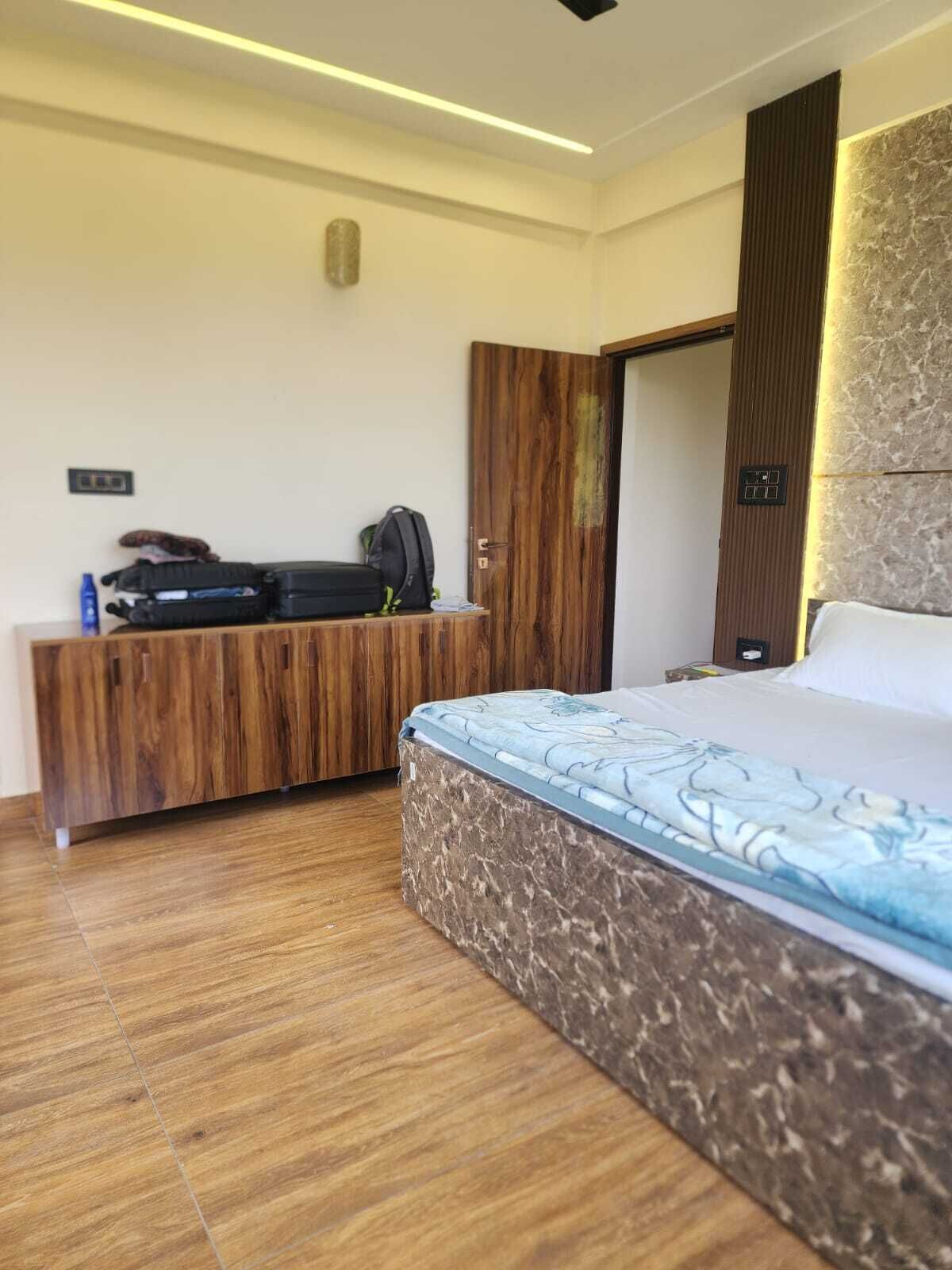 Una habitación de hotel con cama, cómoda de madera y armario.