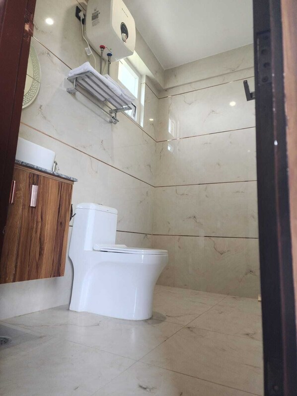 Un baño con inodoro, un armario de madera y un equipo de aire acondicionado de pared.