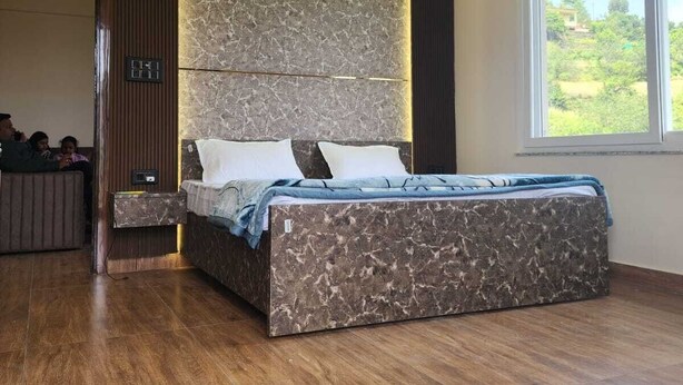 Quarto moderno com uma cama grande, um ventilador de teto e vista para o verde lá fora.
