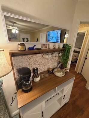 A kitchen with a wooden countertop, a coffee maker, and a TV on the wall. - Gorgeous 3-bedroom bungalow with Hot Tub, Games and AC in Southern Pines (Southern Pines)