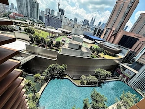Un bâtiment moderne doté d’une piscine sur le toit et entouré de verdure.