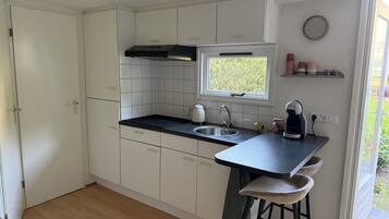 Cafetera o tetera, frigorífico, placa de cocina y utensilios de cocina