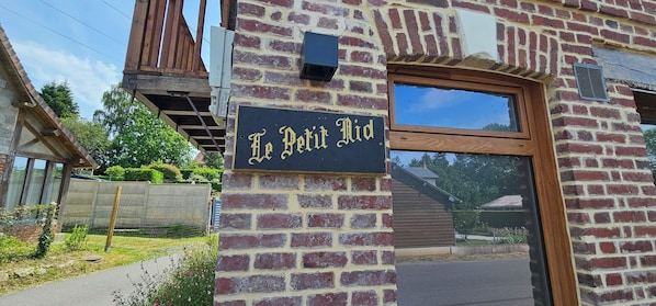 A brick building with a sign reading 'Le Petit Rid' and a window.