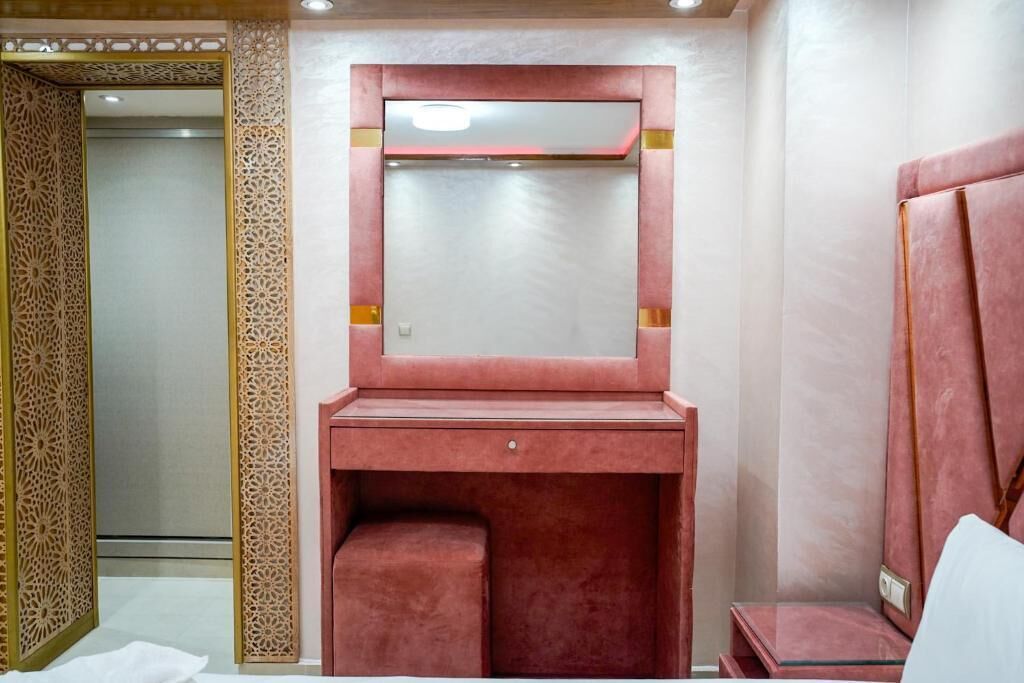 Un baño con tocador, espejo e inodoro.