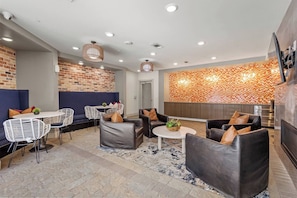 A modern lounge area with seating, a dining table, and a patterned wall. - Midtown Dallas Escape | 1BR 1BA Suite | Pool | Free Parking (Dallas)