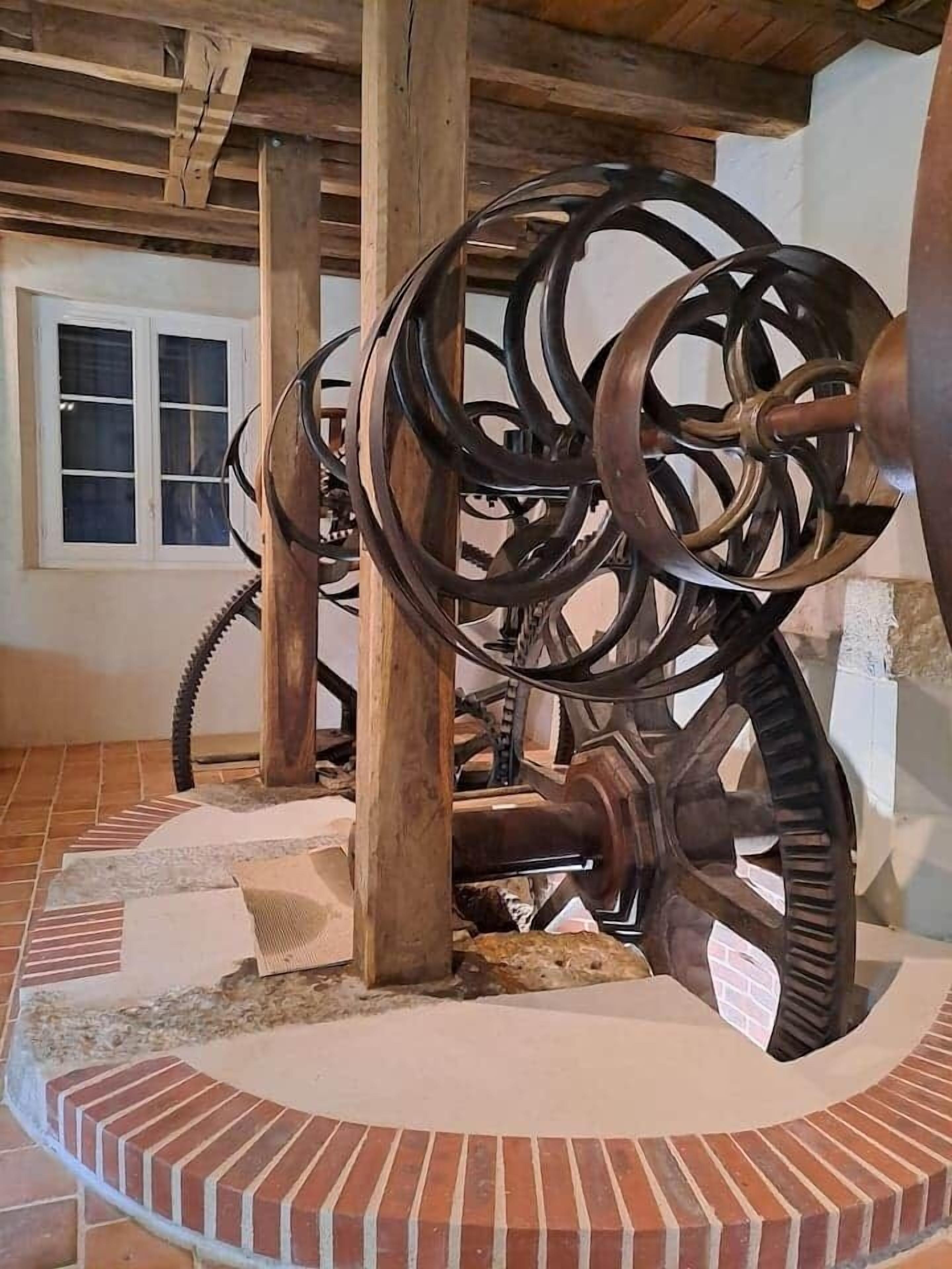 A mechanical device with large wheels and a central shaft, possibly a historical exhibit or installation.