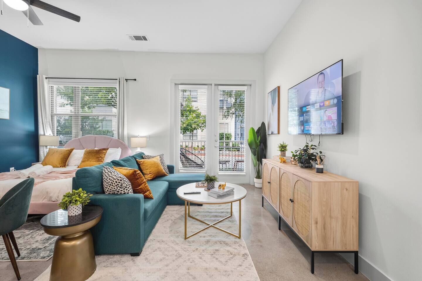 A modern living room with a sofa, a coffee table, and a TV mounted on the wall.