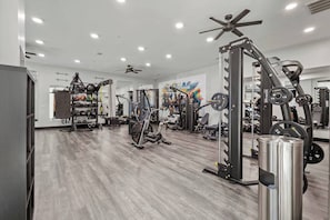 A gym with various exercise equipment, including a Smith machine, weight racks, and cardio machines. - Cozy Lux 1BR 1BA in Dallas | Mins to DT | Free Parking (Dallas)