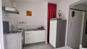 A compact kitchen with a stove, sink, and white cabinets. - A LITTLE CORNER OF THE GARD PROVENCAL (Saint-Gilles)