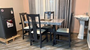 A dining area with a table and chairs, a refrigerator, and a sink. - Perfect 2-bedroom apartment with AC in enjoyable Kampala (Kampala)