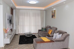 A modern living room with a sofa, a coffee table, and a TV.