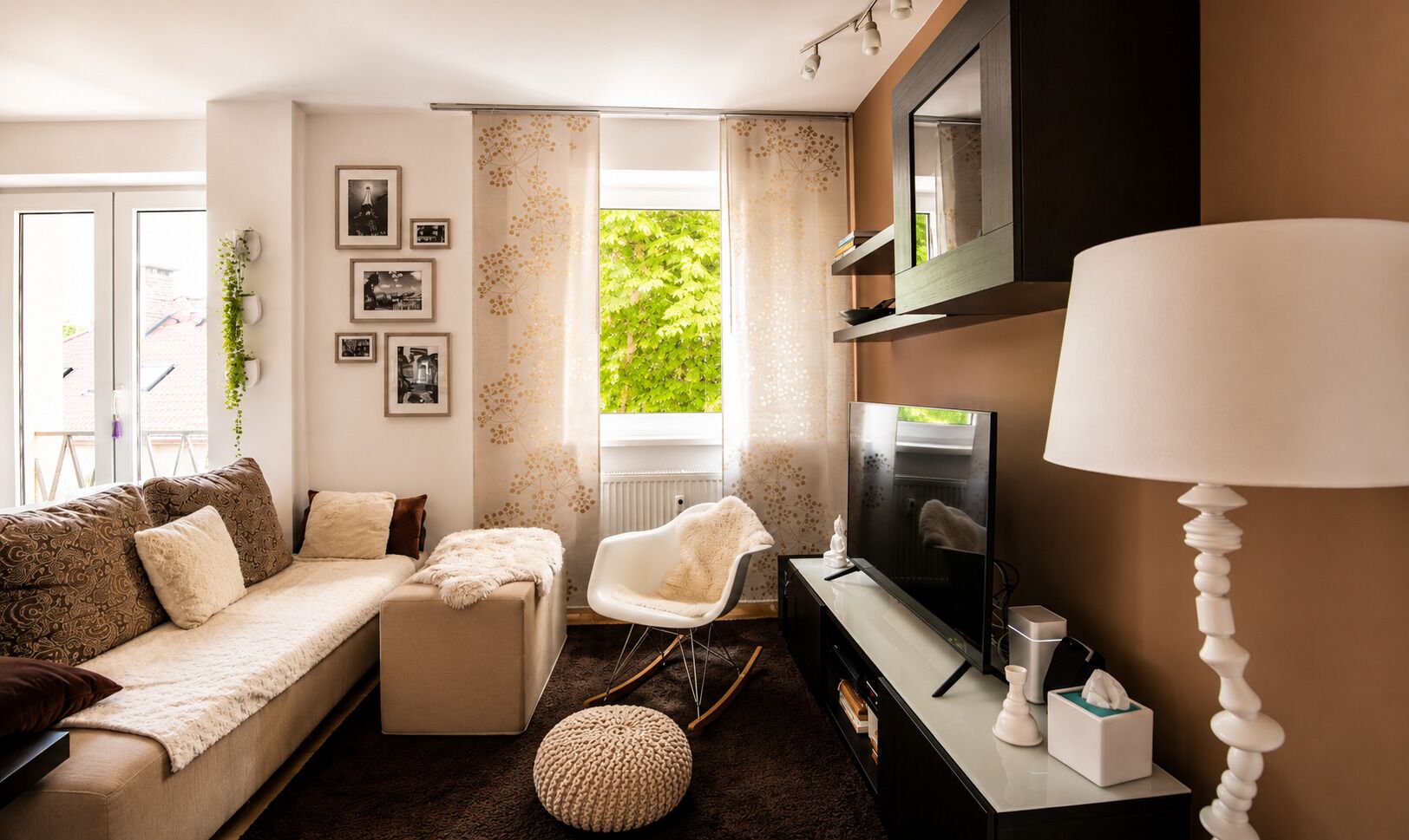 A living room with a sofa, a chair, a television, and a lamp.