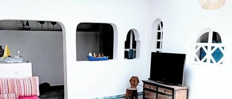 Een moderne woonkamer met een flatscreen televisie, een bank en een salontafel.