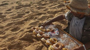 Eine Strandansicht, auf der eine Person ein Tablett mit Essen hält.