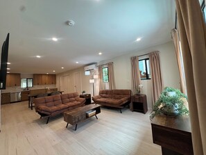A modern living room with sofas, a coffee table, and a kitchen in the background. - Modern 2 bedroom + 2 bath - 10 mins to Rodeo drive and attractions (Beverly Hills)