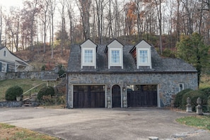 A stone house with a garage and two chimneys.
