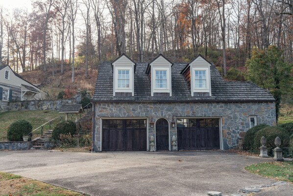 A stone house with a garage and two chimneys.