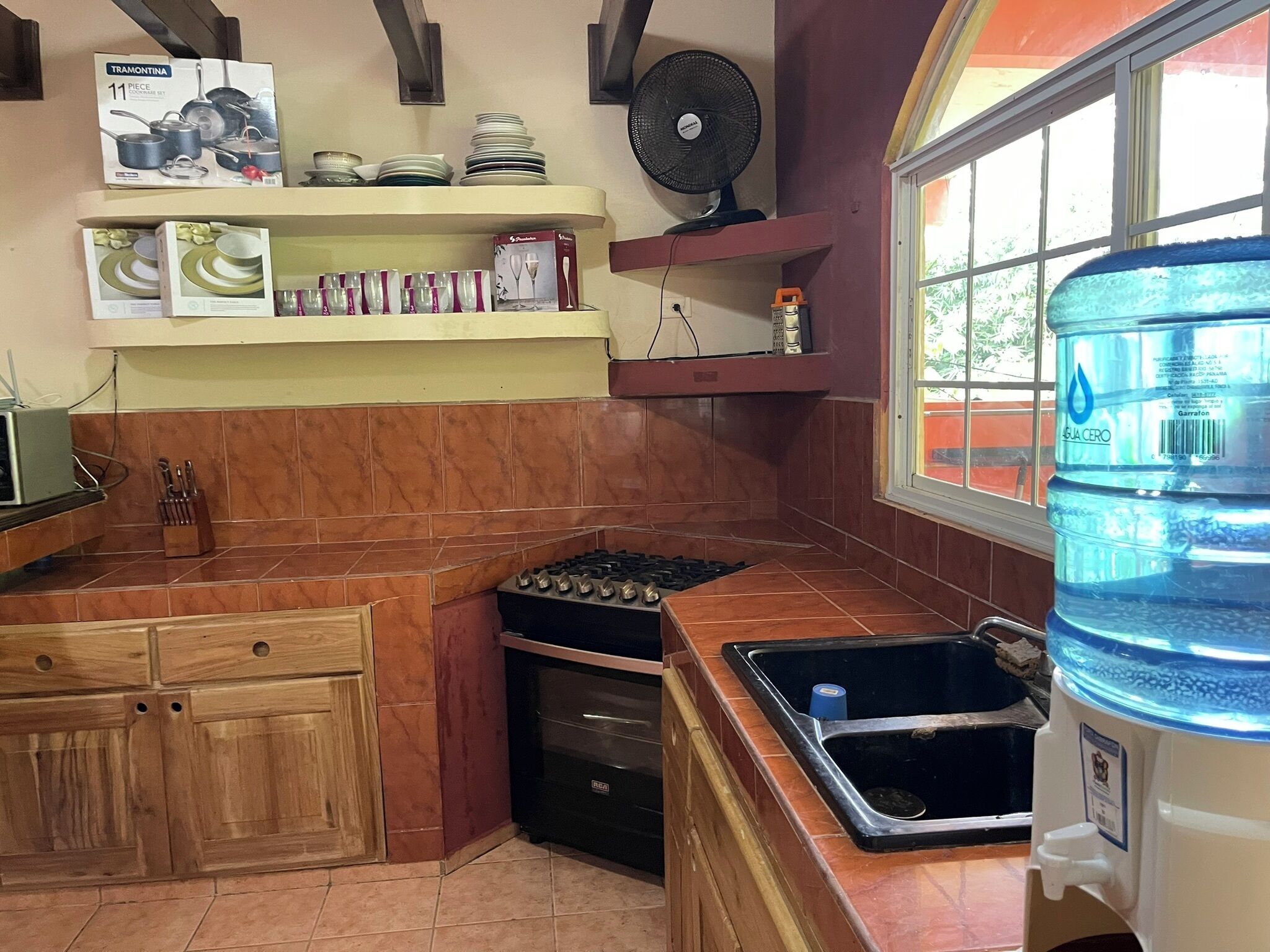 A kitchen with a stove, sink, and a water dispenser.