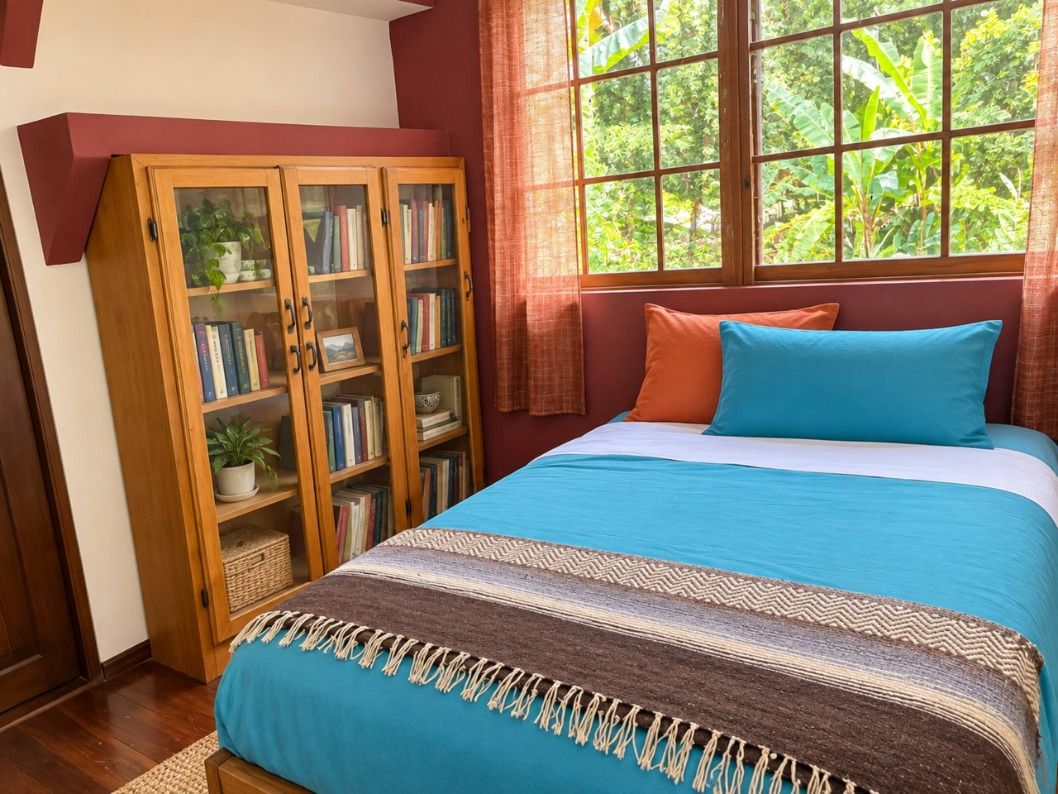 Un dormitorio con una cama, una estantería de madera y un ventanal con vistas a zonas verdes.