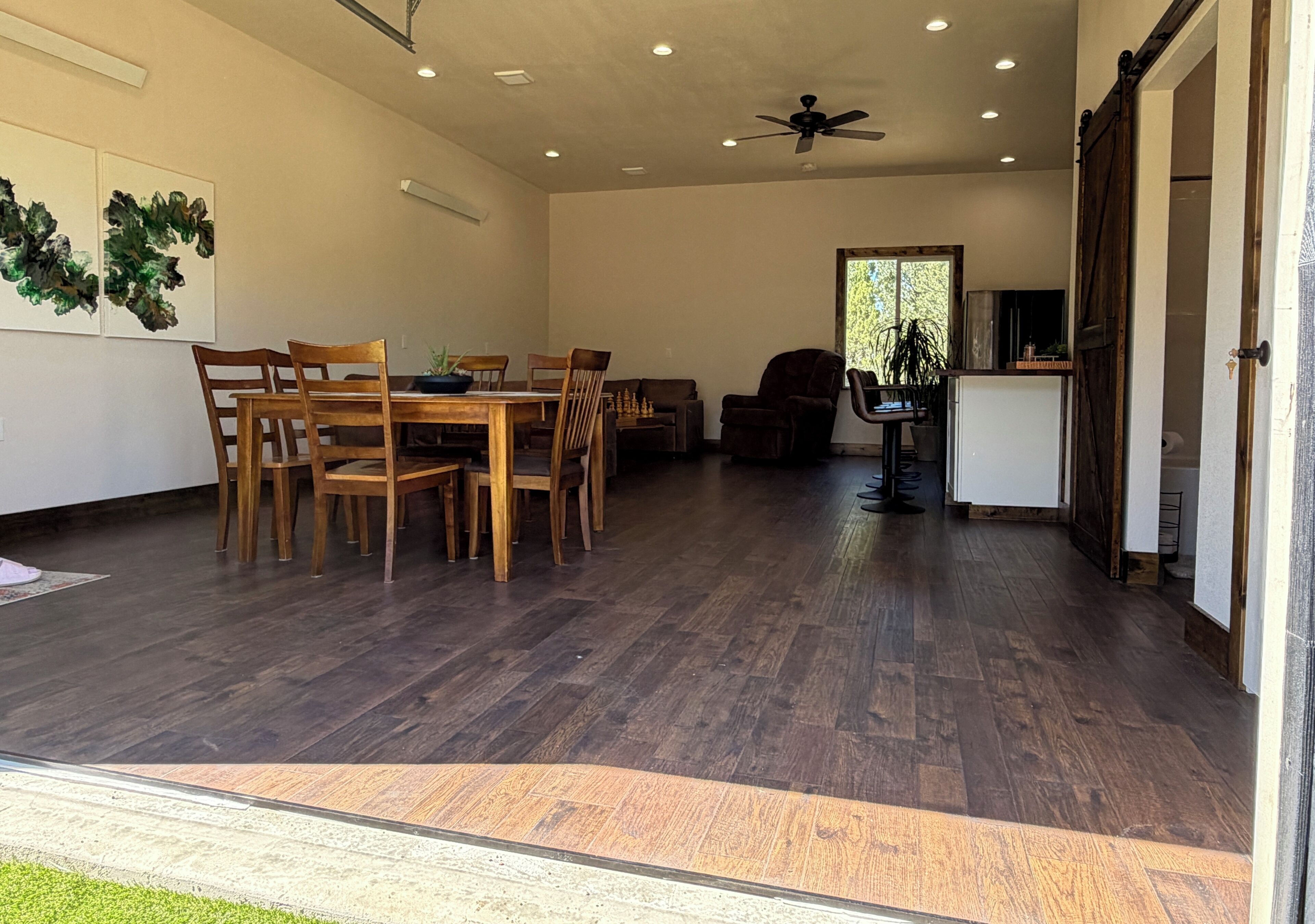 Un vaste espace dédié à la salle à manger, avec des meubles en bois et un ventilateur de plafond.