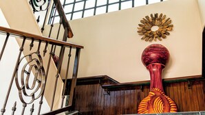 Un escalier avec une rampe en bois et un élément décoratif fixé au mur au-dessus.