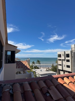 A view of a coastal area with buildings, a clear sky, and the ocean in the distance.