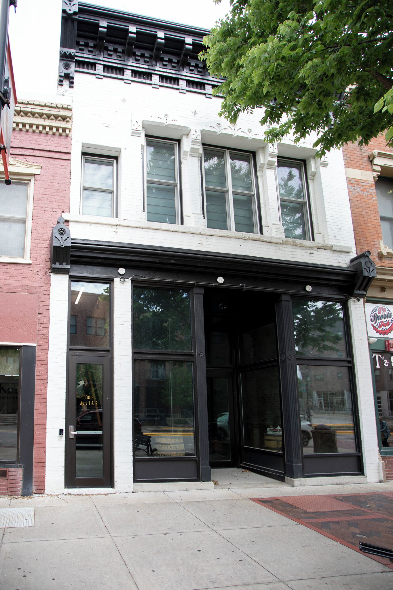 A building with a storefront featuring large glass windows and a black awning.