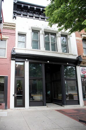 A building with a storefront featuring large glass windows and a black awning.